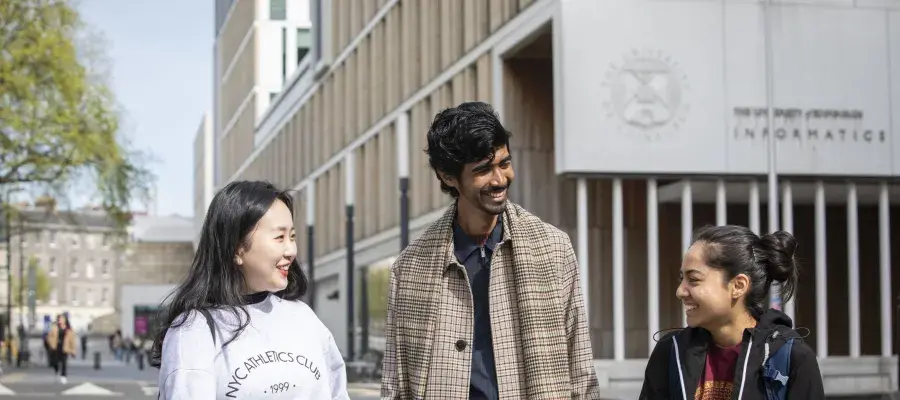 Three students walking outside the Informatics building