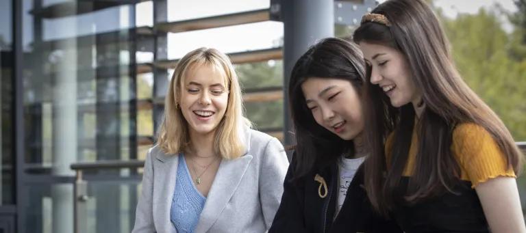 Three students around a computer outside Murray Library