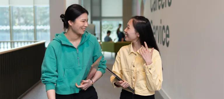 Image of two students walking past the Careers Service at Kings Buildings 