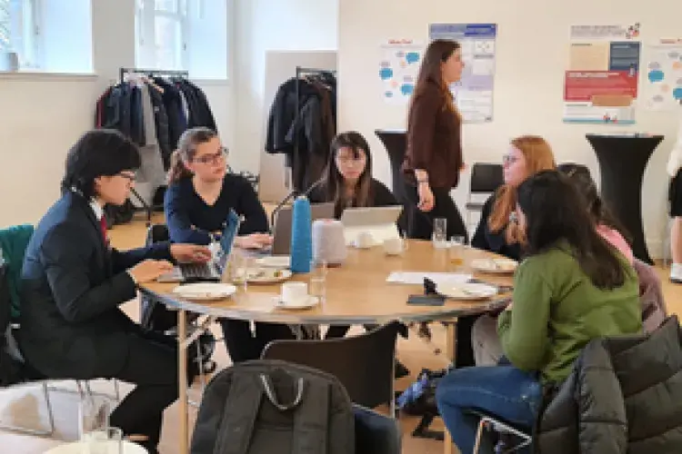 Students sitting around a table at the SACHA Think Tank final event.